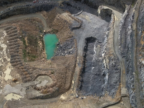 Montrose, Victoria, Australia - 26 August 2026: Aerial view of Boral Montrose quarry showing deep excavation pits, rocky terrain, and a turquoise water pool.