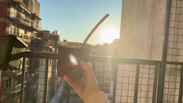 Traditional Argentine Mate Tea Infusion Warm Drink Lifestyle Scene on terrace, balcony, rooftop a Spring Day, Latin America. Typical social drink from Argentina, Uruguay, Paraguay and Brazil