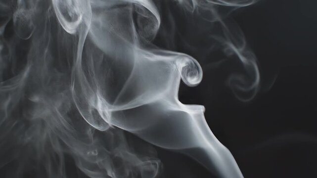 White smoke wisps swirling elegantly against a dark backdrop with subtle motion and selective focus
