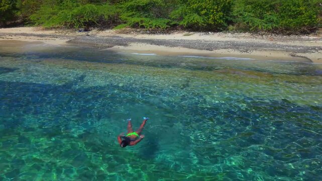 Aerial Drone View of a girl swimming in Crystal Clear Waters at Tamarindo Beach Culebra