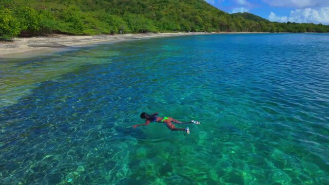 Clear Water Ocean Aerial Drone of a girl in bikini swimming Shot Tamarindo Beach Culebra Island