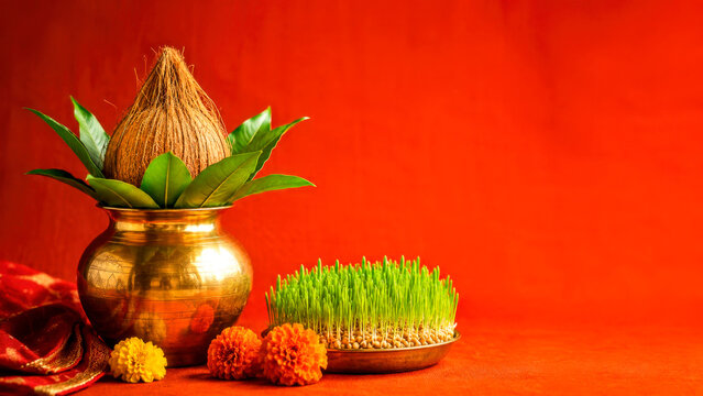 Navratri Ghatasthapana Kalash with Coconut, Mango Leaves, Barley Sprouts and Marigold Flowers on Red Background