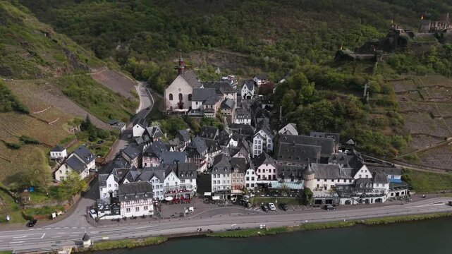 Aerial footage slowly tilting down over the town of Cochem, Germany, revealing its beautiful historic buildings on the Moselle river