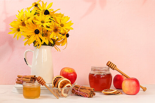 Autumn banner with a beautiful bouquet of rudbeckia in a vase, honey, apples, dried orange, cinnamon and star anise on an elegant background, autumn greeting and gratitude concept, cozy composition