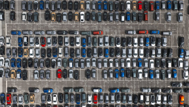 Spain - 22 August 2026: Aerial view of new cars parked on a parking lot waiting to be transported for export, arranged in neat rows on asphalt.