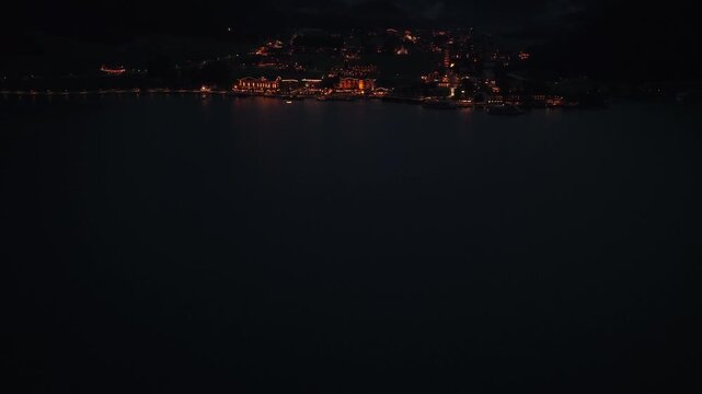 Aerial Tilt Up Above Illuminated Achensee Lakeside Town and Alpine Mountains, Austria