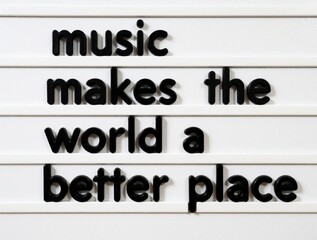 Obraz premium Black plastic letters on white board form inspirational quote. Music makes world better place text message. Creative typography design for positive message, peace concept, lifestyle banner, social
