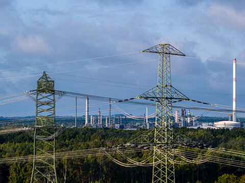 SchwedtOder, Germany - 20 August 2026: Aerial view of PCK Raffinerie GmbH with high-voltage power lines in the foreground and industrial structures under a cloudy sky.