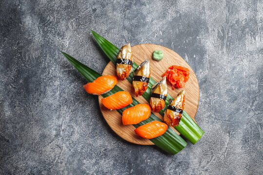Sashimi sushi set on wooden board. Stone background. Top view