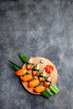 Sashimi sushi set on wooden board. Stone background. Top view