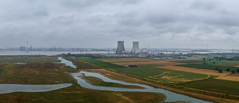 Beveren-Kruibeke-Zwijndrecht, Belgium - 18 August 2026: Aerial view of the Doel Nuclear Power Plant along the Scheldt river, surrounded by agricultural fields and wetlands under a cloudy sky.