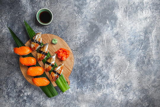 Sashimi sushi set on wooden board. Stone background. Top view