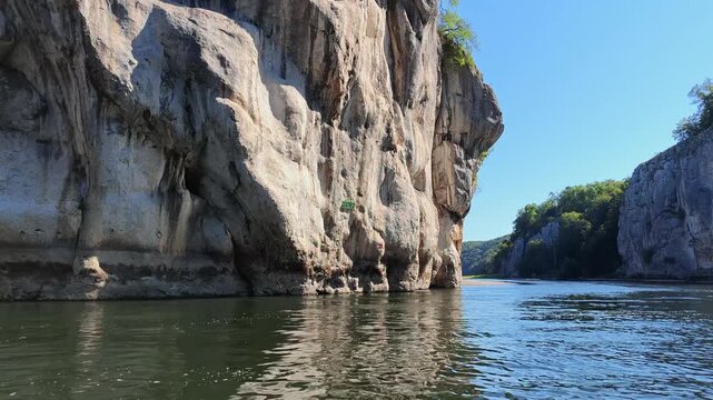 Picturesque landscape of the Danube Gorge with its stunning limestone rock formations reflecting on the water surface on a sunny day