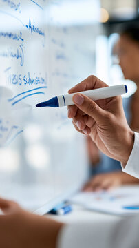 close up of hand using blue marker to underline the words thesis submission written on a bright whiteboard clean modern office natural light hands only in frame bright whiteboard