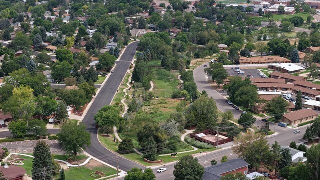 Loveland, United States - 14 August 2026: Aerial view of Benson Sculpture Garden featuring winding paths, lush green trees, and surrounding residential streets in a suburban landscape.