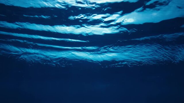 Underwater ocean waves flowing in deep blue light