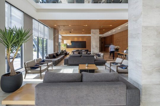 Modern luxury hotel lobby area with comfortable gray sofas and elegant marble interior