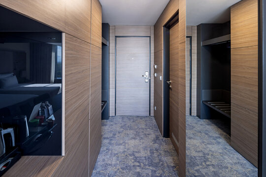 Modern luxury hotel room hallway featuring elegant wooden wall panelling and full length mirror