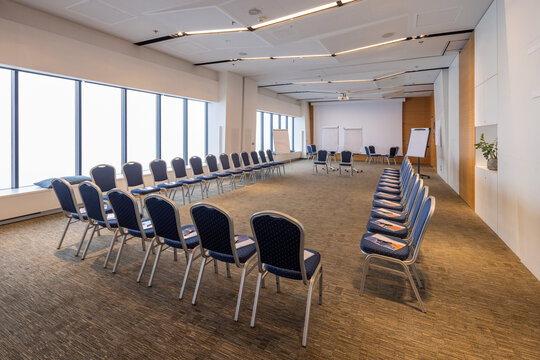 Empty modern conference room with blue chairs arranged in a circle for business seminar presentation