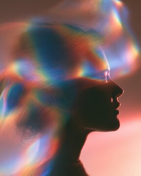 A silhouette shows flowing rainbow light waves in a blend. This captures sensory perception in a unique and colorful way.