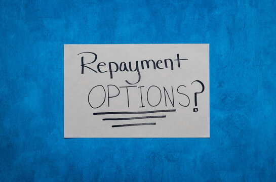 Repayment Options? Flat lay money management concept photo hand written on white paper and blue background.