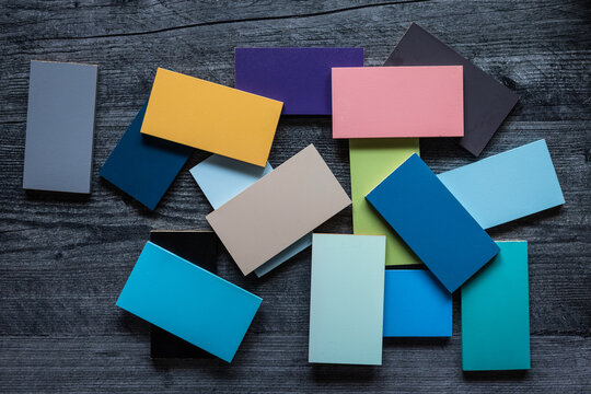 Over head view of scattered colorful rectangular wooden tiles on dark gray wood background