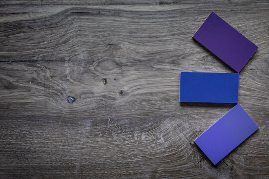 Flat lay photo with negative space dark grey wooden background with purple blue tiles. 