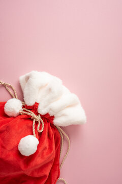 Merry Christmas Santa sack with present and Happy New Year gift bag on pink vertical background