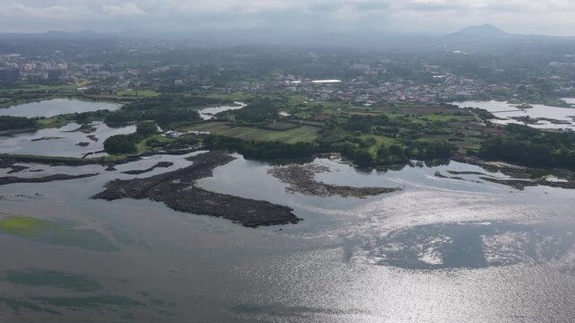 Aerial View Of Ojo-ri Wetland Protection Area With Glistening Water In Seongsan-eup, Seogwipo-si, Jeju-do, South Korea.