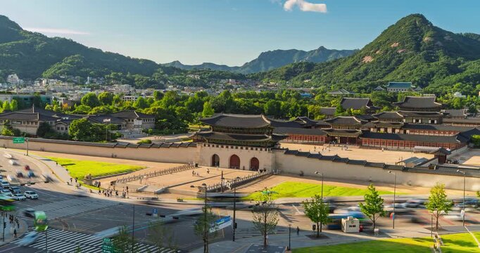 Camera zooms slowly toward Gwanghwamun Gate at Gyeongbokgung Palace in Seoul, South Korea while traffic streaks past below Bugaksan mountain skyline