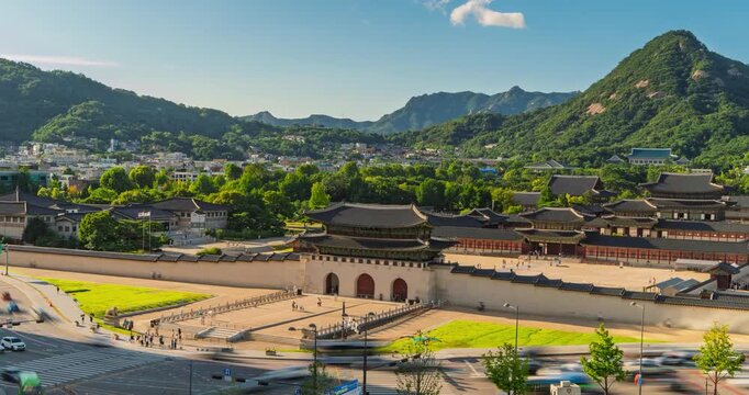 Hyperlapse pulls back from Gwanghwamun Gate to reveal Gyeongbokgung Palace, streaming traffic and tourists beneath scenic Bugaksan mountain in Seoul