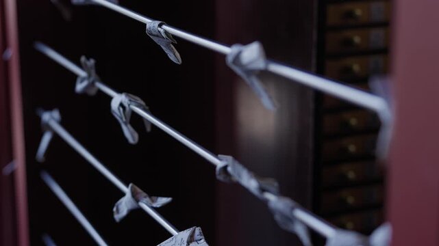 Rows of white paper fortunes knotted along wires at a shrine in Japan