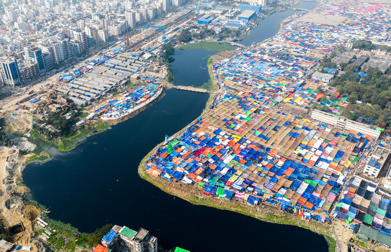 Aerial view of the Bishwa Ijtema gathering with thousands of colorful tents and shelters set up along the riverbank in the urban landscape of Tongi, Dhaka Division, Bangladesh.