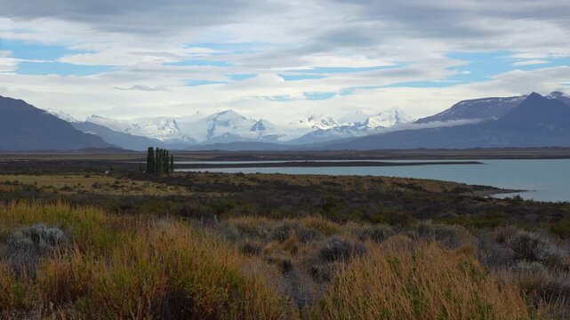 Scenic landscape of Patagonia with snow capped mountains, lake and dry vegetation in Argentina