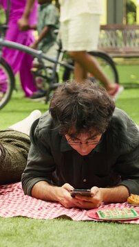 Portrait format: Young couple show phubbing and phone addiction during picnic