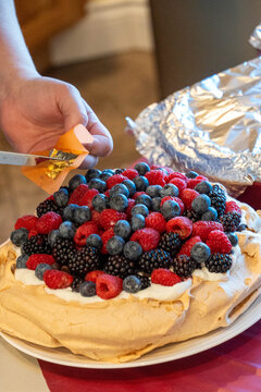 Berry topped pavlova being sliced
