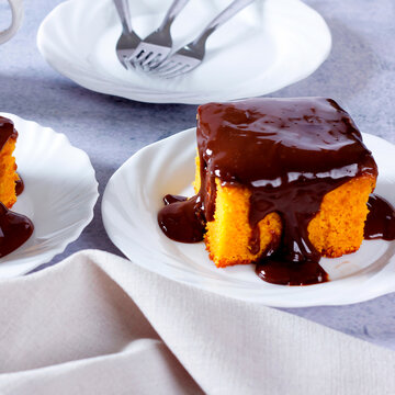 Brazilian carrot cake with a soft crumb and creamy chocolate frosting on a white plate.