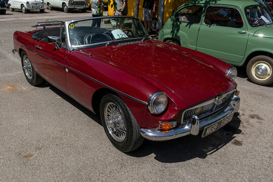 Tavernes Blanques, Spain - June 14, 2026. Dark red vintage MGB Roadster with chrome wire wheels at a summer car show
