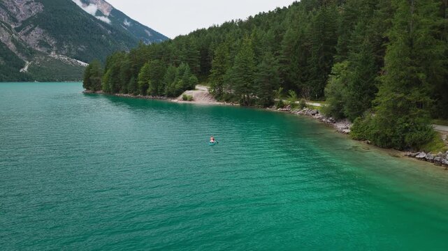 Aerial Flight Lake Achensee Tyrol Austria Natural Clean Water Mountain Landscape with Woman Stand Up Paddle Boarding