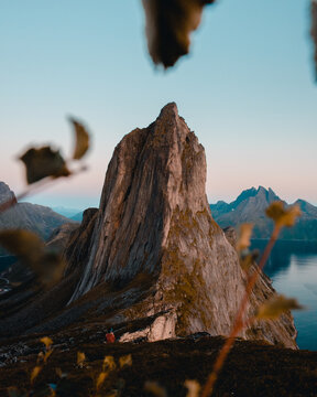 Aerial view of the iconic Segla mountain peak rising above the deep blue waters of the fjord in Senja, Troms, Norway.