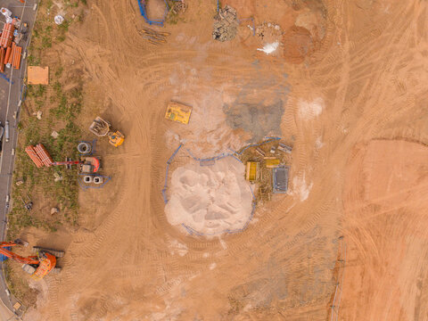 Stafford, England, United Kingdom - 16 August 2026: Aerial view of the construction site at Creswell, featuring heavy machinery, piles of sand, and tire tracks on the bare earth.