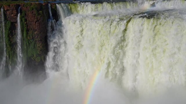 Aerial view of the powerful waterfalls with a rainbow in the mist