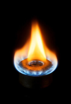 Natural gas flame on a burner energy crisis and rising utility costs heating and cooking fuel dark background