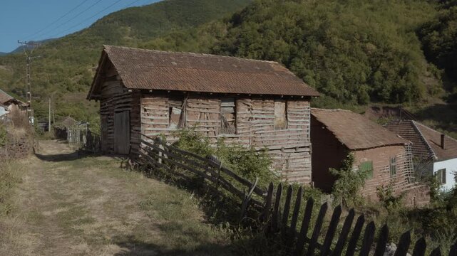 Static medium shot of a traditional old mud brick and timber house with tile roof in Topli Do village, Stara Planina, Serbia. Cinematic view of authentic rustic Balkan architecture.