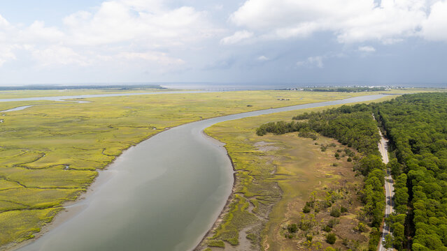Drone view of river and landscape with grasslands in remote area near coast