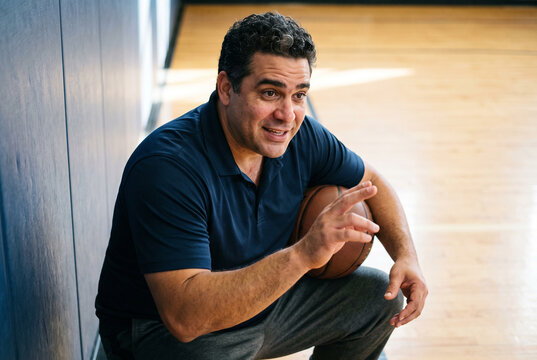Basketball Coach Talking Courtside in Indoor Gym