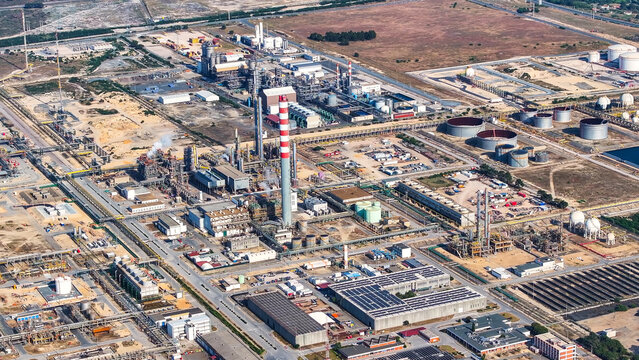 Aerial view of the large oil refinery and industrial manufacturing complex in Sines, featuring tall chimneys, storage tanks, and extensive infrastructure in Sines, Setubal, Portugal.
