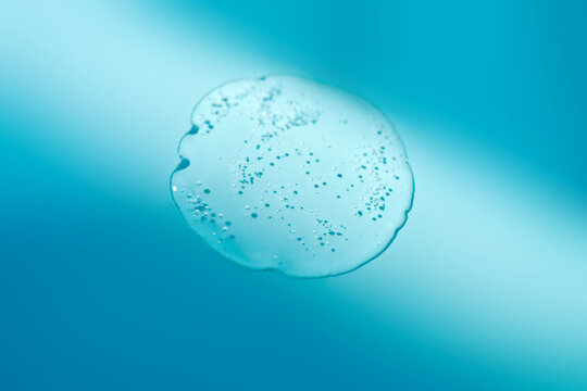 Cosmetic gel serum drop texture on blue background