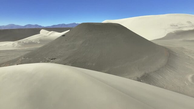 Volcanic cinder cone amid dunes in La Puna highland desert