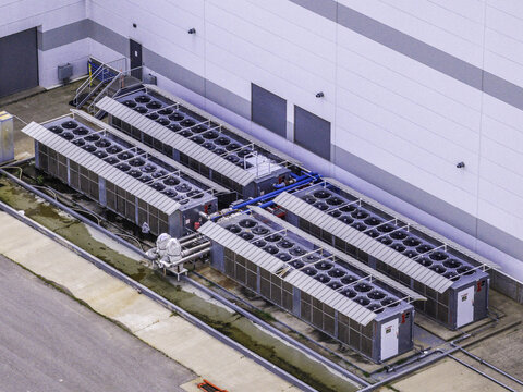 Aerial view of large industrial air cooled chillers and condenser units for a building cooling system installed on a concrete pad in Clarksville, Tennessee, United States.